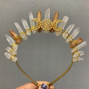 Detail of handmade crown with raw crystals and gold triple moon symbol being held