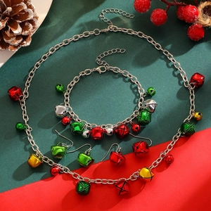 Flat lay of Christmas jewelry set with colorful bells on festive pine cone background