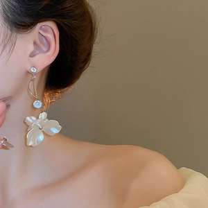 Détail de boucles d'oreilles fleur à pampilles, fini argent et détails en zircon