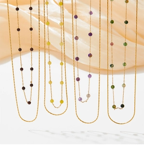 Detail of four gold necklaces with natural garnet, topaz, amethyst and green agate beads