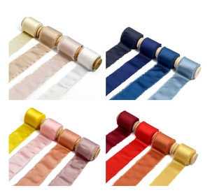 Macro view of assorted frayed edge silk ribbons on wood spools in multiple soft colors