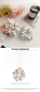 Close-up of a white polka dot fabric scrunchie with a cute plush rabbit charm