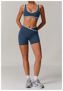 Detail of high-waist crisscross shorts and blue sports top with white trim accents