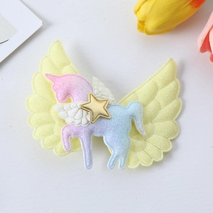 Detailed view of a glittery pink unicorn hair clip with yellow wings and gold star