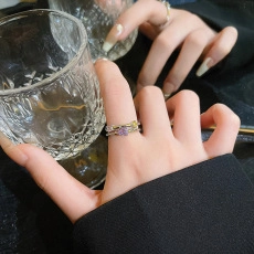 Detail of a double-layered ring with a purple heart-shaped stone and yellow zircon on hand