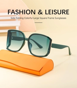 Close-up of curved gradient sunglasses with an orange case on geometric props