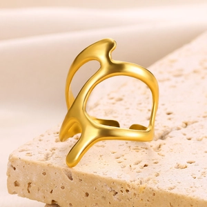 Detailed view of an irregular 18k gold water drop ring on a textured limestone base