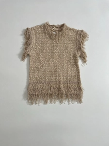 Detailed flat lay of beige sleeveless knit top featuring textured fringe trim and button collar
