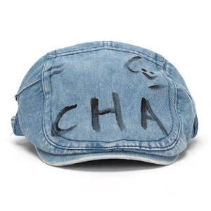Retro washed denim newsboy cap with black graffiti letters for a vintage urban look