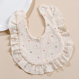 Detail of soft four-layer cotton muslin bib with ruffled edges and colored polka dots