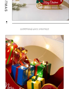 Close-up of red metal Christmas sleigh with gift boxes and glowing fairy lights decor