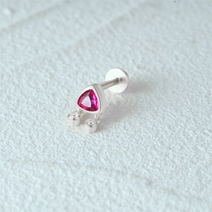 Macro shot of silver earring with pink triangle gem and clear round stones