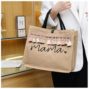 Detail of jute tote bag featuring colorful tassels and Mama letter print with heart