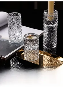 Detailed close-up of geometric glass candle holders set on a luxury gold metal tray