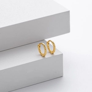 Macro view of gold-plated S925 sterling silver twisted rope texture huggie hoop earring