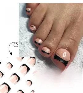 Detail of French press-on toenails with black tips, gold glitter lines and star patterns
