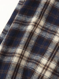 Detail view of plaid fabric texture with frayed edges and soft brushed flannel finish
