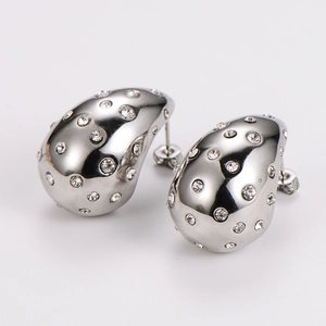 Macro shot of silver teardrop earrings with shimmering rhinestones on a studio background