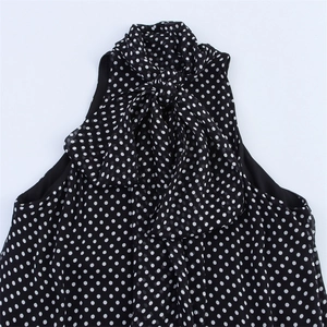 Close-up of halter neckline with bow-tie detail on black polka dot chiffon dress