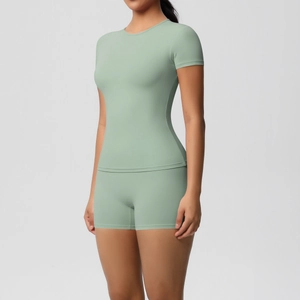 Close-up of slim-fit light green athletic T-shirt and high-stretch yoga shorts on model