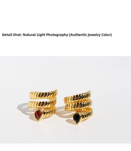 Detail view of triple-layered golden snake rings featuring pear-cut zircon stone settings