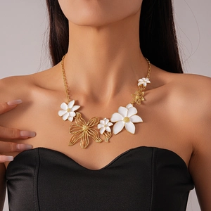 Detail of the oversized gold flower necklace with white enamel petals on a model