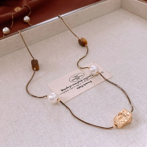 Détail du collier chaîne serpent dorée avec perles et perles de couleur ambre