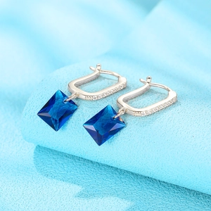 Detailed close-up of S925 silver U-shaped hoop earrings with blue square-cut gemstones