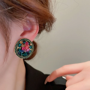 Vintage gold clip-on earrings with colorful rhinestones on elegant model close-up
