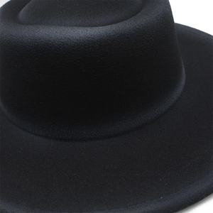 Close-up of the textured wool felt material and stitching on a wide-brimmed black fedora hat