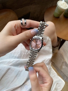 Elegant women's watch with pink dial, silver steel band and diamond markers on wrist