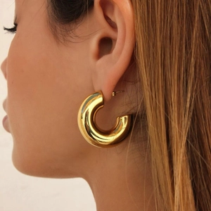 Nahaufnahme von minimalistischen 18K vergoldeten C-Ring-Ohrringen an einem Modell