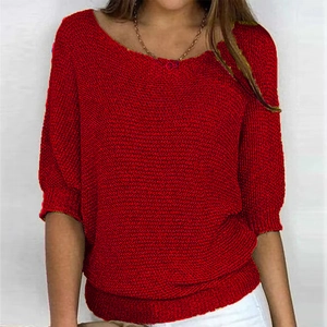 Detail eines roten Strickpullovers mit Rippbündchen und lockerem Fledermausärmel