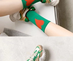 Detail of green ribbed cotton mid-calf socks with red heart motif and retro sneakers