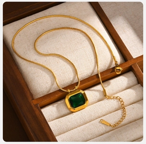 Detail of emerald green square stone pendant on gold stainless steel chain with lobster clasp