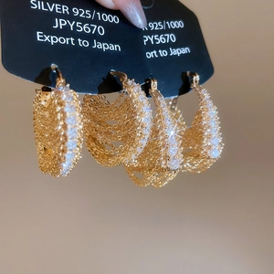 Macro detail of 18k gold plated 925 silver chain earrings with sparkling cubic zirconia