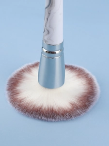 Detail of fan-shaped powder brush with marble handle and soft gradient bristles