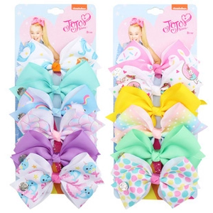 Close-up of ten colorful handmade bow clips for girls with vibrant patterns and metal clips