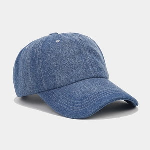 Detail of vintage blue denim baseball cap showing white contrast stitching and soft fabric