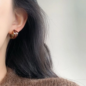 Elegant vintage enamel gold hoop earrings in dark brown, worn by a female model