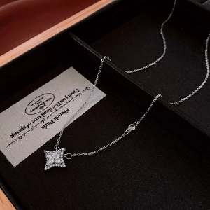 Macro detail of a silver star pendant with cubic zirconia on a luxury black gift box