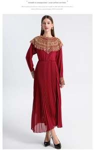 Detail of gold beaded sequins and embroidery on a deep red pleated chiffon dress