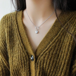 Elegant 925 sterling silver heart necklace with OT toggle clasp on green cardigan