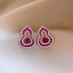Macro shot of silver gourd earrings with pink gemstones and pavé-set crystals