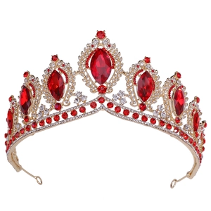 Macro detail of golden baroque bridal crown featuring ruby red crystals and diamonds