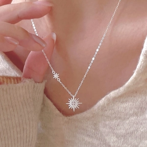 Elegant 925 sterling silver starburst necklace worn by a model on a beige sweater