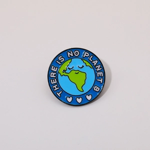 Detailed view of enamel Earth badge featuring There is no planet B slogan and heart icons