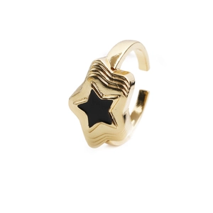 Detailed close-up of gold star ring with black enamel center and adjustable open band