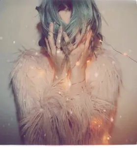Detail of pink faux fur coat with soft fluffy texture and warm holiday fairy lights
