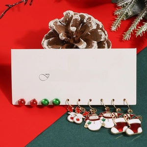 Close-up of five pairs of Christmas earrings with reindeer, snowman and sock charms